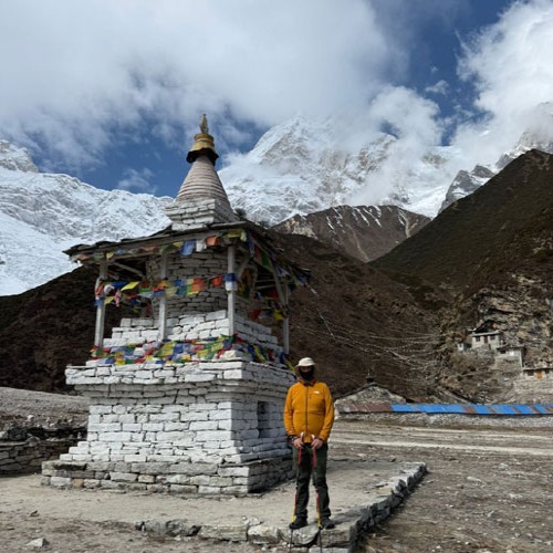 Trekkers walking on Manaslu Circuit trail with chorten and mountain landscape