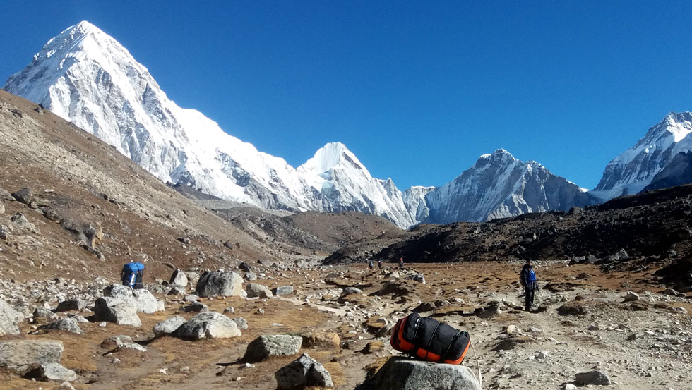 Trekkers walking toward Everest Base Camp with Himalayan mountain views