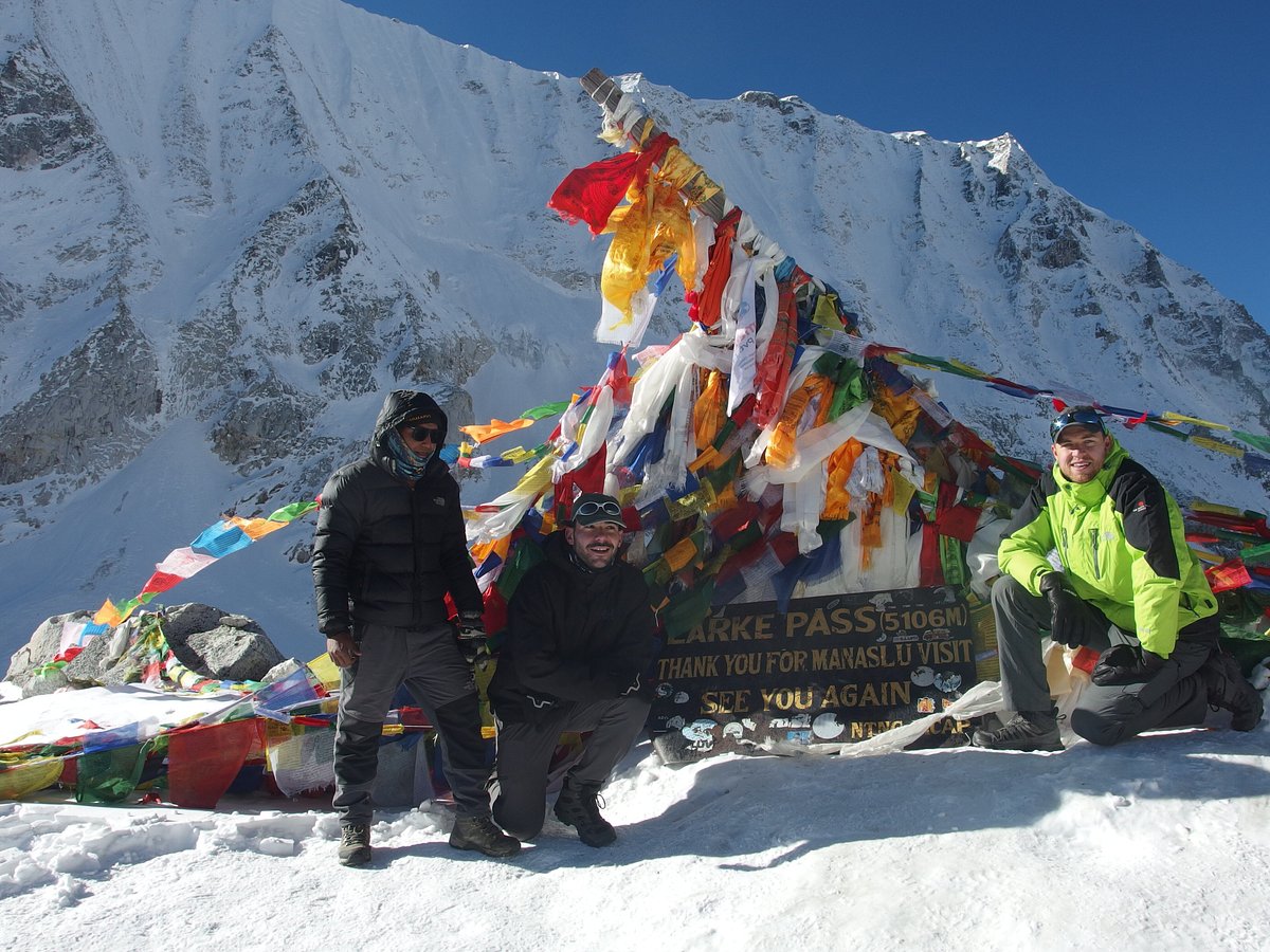 Trekker crossing Larkya La Pass on the Manaslu Circuit with panoramic Himalayan views