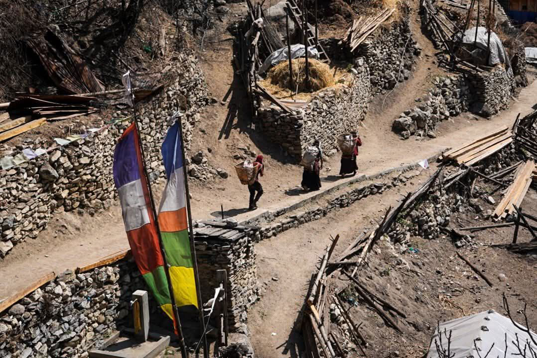 Local villagers walking along mountain trail for daily work during Manaslu Circuit Trek in Nepal