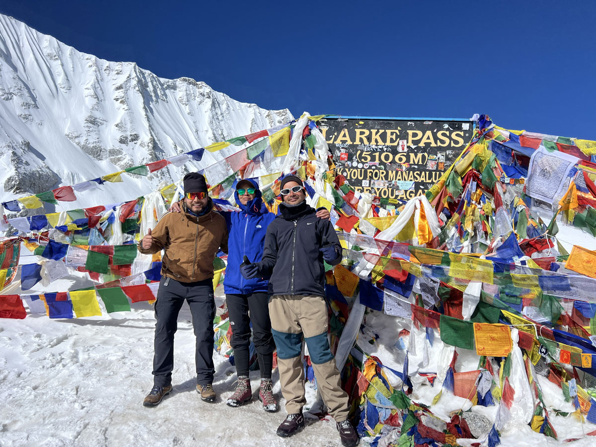 Solo female trekker with guide and porter at Larkya La Pass Manaslu