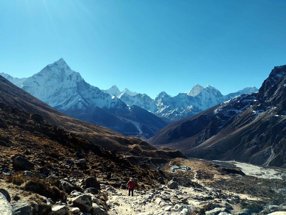Trekkers walking toward Everest Base Camp with mountain views